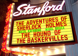 Neon night-time Stanford Theatre marquee features Sherlock Holmes